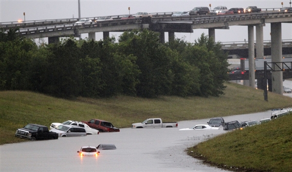 A moody, rain-soaked highway scene with soft gray skies and distant traffic, evoking reflection and the passage of seasons